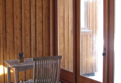 A sunroom with a table and chair at Redstone Cabin in Redstone Colorado.