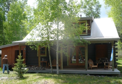 Exterior view of Redstone Cabin in spring surrounded in green in Redstone Colorado.