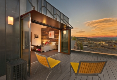 Looking into the bedroom from the balcony of Truckee Prototype Mixed-Use Townhouse in Truckee, California at dusk..