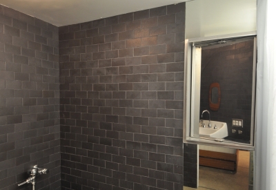 Bathroom covered in black tile inside Shotwell Garden Retreat in San Francisco.