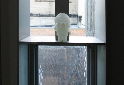 A pivot window in open position with a small astronaut figurine on it at Shotwell Design Lab in San Francisco. 