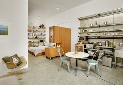 Interior view of the kitchen and dining area with sleeping area in the background in Shotwell Garden Retreat in San Francisco.