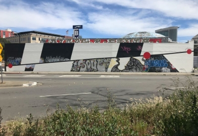 Exterior street view of the side of David Baker Architects Office covered in street art in Oakland, California.