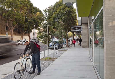 Person locking bike outside Richardson Apartments in San Francisco.