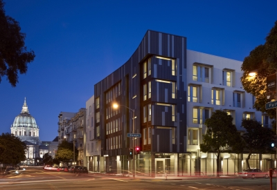 Night view of Richardson Apartments with City Hall dome in background in San Francisco.