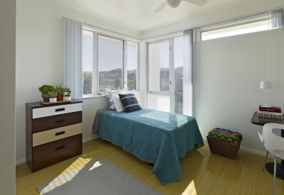 Interior of furnished studio apartment, with city view through window