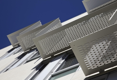 Detail of aluminum sunshades on white stucco bay at Richardson Apartments in San Francisco.