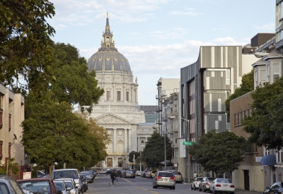 Street level view down Fulton Street toward San Francisco City Hall dome, showing Richardson Apartments corner bay in context