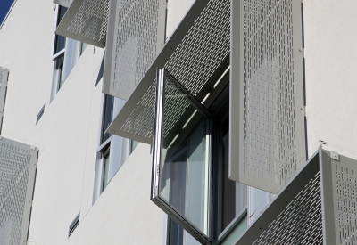 Detail of aluminum sunshades on a white wall at Richardson Apartments