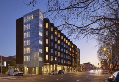 Exterior view at dusk of Tahanan Supportive Housing in San Francisco.