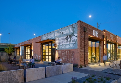 View of the multiple people enjoying the open courtyard at dusk at the Bandsaw Building in Birmingham, Alabama.