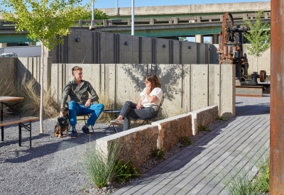 Two people and a dog sitting in the open courtyard at the Bandsaw Building in Birmingham, Alabama.