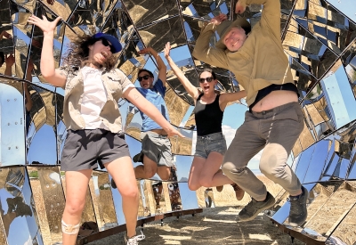A group of people in jumping up inside peepSHOW in the desert in New Cuyama, California.