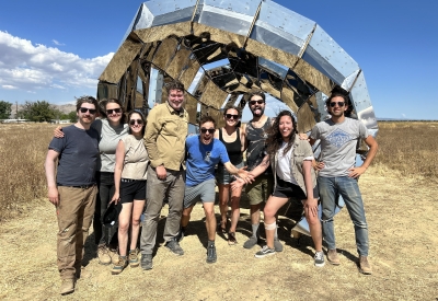 A group of people standing in front of peepSHOW in the desert in New Cuyama, California.