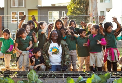 Women standing with a group of children at the Vegetation at the Acta Non Verba Farm in Oakland, California.