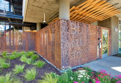 Detail view of greenery in front of the cor-ten steel entry fence at Blue Oak Landing in Vallejo, California.