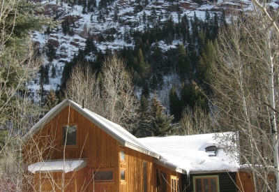 Exterior rear view of Redstone Cabin covered in snow in Redstone Colorado.