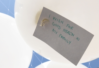 Detail of one of the Wishing Cloud balloons with the a note attached wishing for good health for their family.