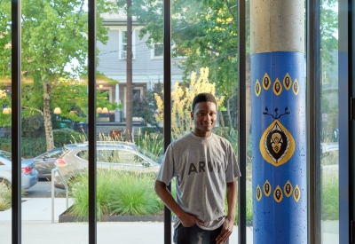 Young man posing in the entry lounge of Africatown Plaza in Seattle.