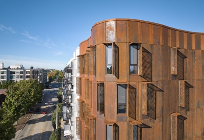 Detail view of the weathered steel facade and curve of Africatown Plaza in Seattle.