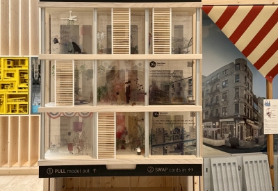 Model on display in a plywood pavilion