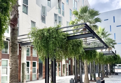 View of outdoor passage of white building against blue sky