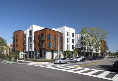 Corner view of a modern building with rusted-steel and white volumes. 
