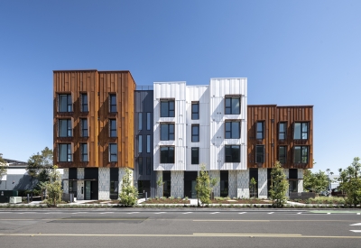 Elevation view of a modern building with rusted-steel and white volumes. 