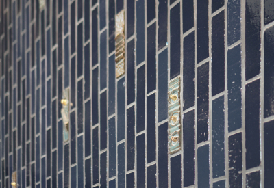 Closeup view of blue tiled wall with custom textured highlight tiles