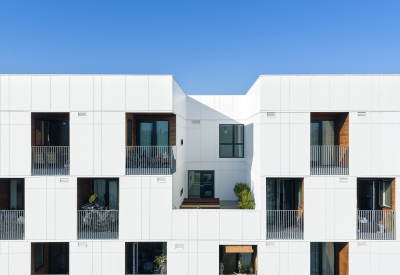 Close up of balconies in checkerboard pattern in white apartment building against blue sky
