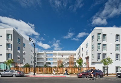 Image of a courtyard and open-air circulation linking two wings of a large white building