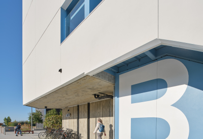 White building with white letter B on a light blue wall