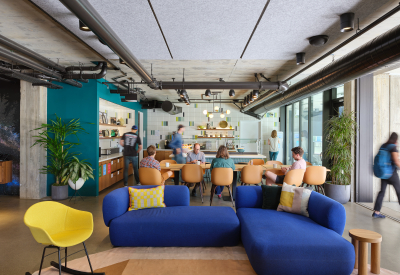 Lounge space with large dining table and blue sofa in foreground