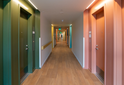 Hallways with apartment entries boasts bold colors -- green and peach -- for wayfinding
