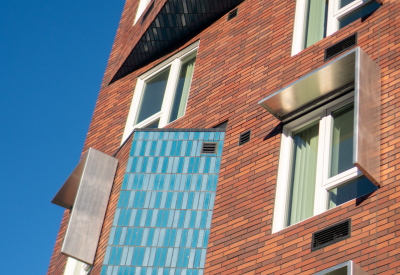 Exterior detail showing vibrant blue brick contrasting with terra-cotta-color brick