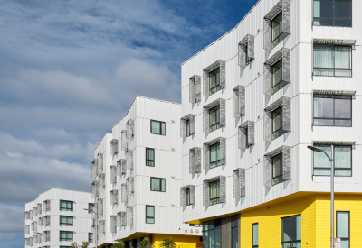 Street view of apartment building with cyclist in the foreground