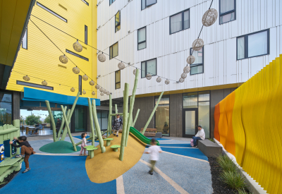 Children play on outdoor equipment in a courtyard