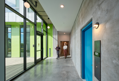Ground floor unit door on right; daylight hallway with people