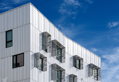 Detail view showing the perforated metal sunshades around the apartment windows