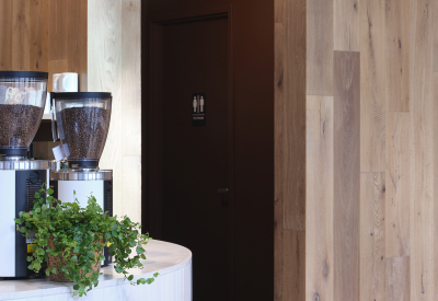 A gap in the wood wall leads to the restrooms and support space