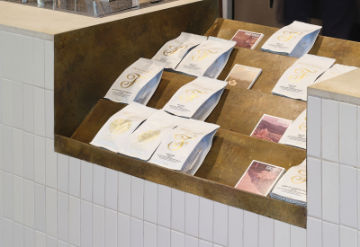 A cutout in the countertop serves as a display case for bags of coffee and other goods