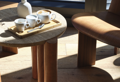 A trio of coffee drinks on a small table near the window