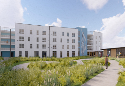 White building with blue and plants in foreground and blue sky background