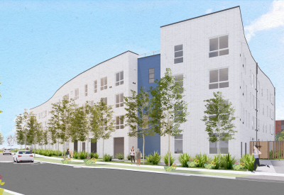 White building with blue and trees in foreground and blue sky background