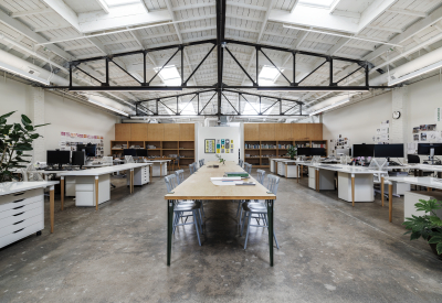 White interior space with black truss and long table down the center of the room