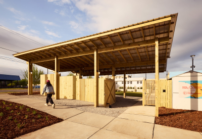 Front sidewalk and shade pavilion over an entry gate