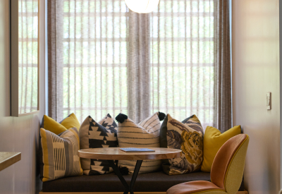 Room nook with built in bench and woven pillows in front of window