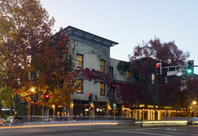 Dusk view of corner hotel with with fall trees