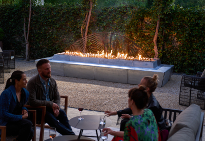 Sculptural concrete and steel fire feature with flames with seating area in front