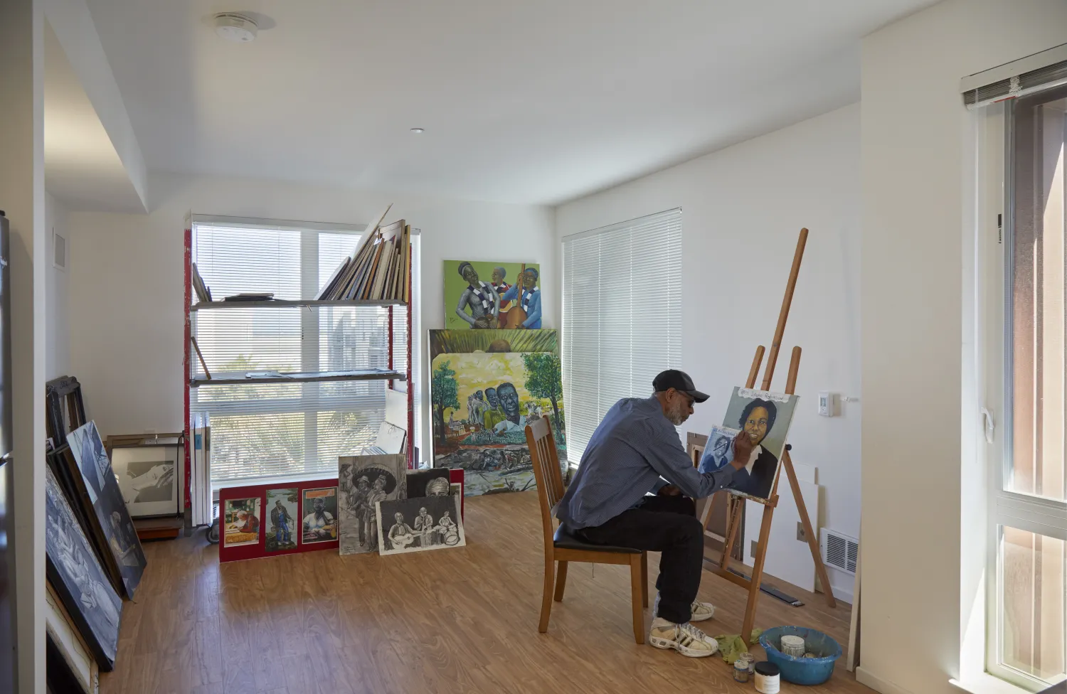 Resident painting inside of his apartment in Dr. George Davis Senior Building in San Francisco.